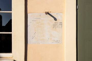 A Wall sundial With Hebrew Text And A Shadow From A Hook.