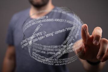 A person interacts with a digital sphere displaying internet code, representing data and technology.