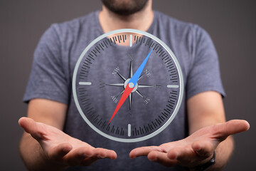 Stock photo of a man holding a compass, symbolizing guidance, direction, and navigation.