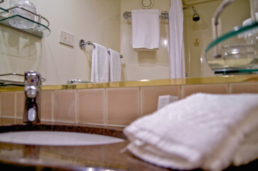 Classic interior design inside bathroom with sink, shower and towels inside cabin stateroom onboard...
