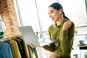 Confident young businesswoman reviewing ideas on a laptop while working in her stylish atelier workspace