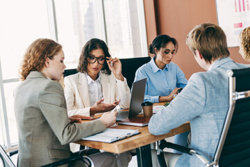 Professional business team collaborating on project in a modern office environment with focus on teamwork and organization