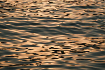 Golden blue sparkling water under the sunset