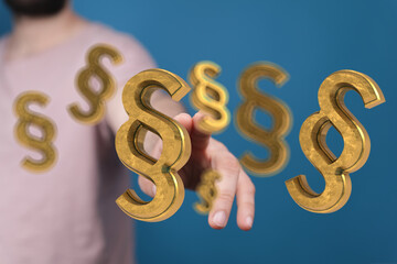Abstract image of golden paragraph symbols floating towards a hand, ideal for legal or law-related...