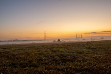The dawn fog shrouded the high-voltage power poles. Early morning, foggy haze