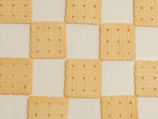 Square crackers piled on white background