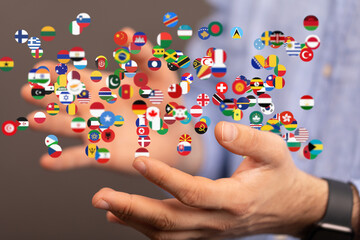 Image of hands gently holding numerous flags, symbolizing global unity and international relations.