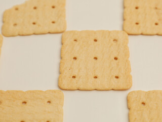 Square crackers piled on white background