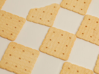 Square crackers piled on white background