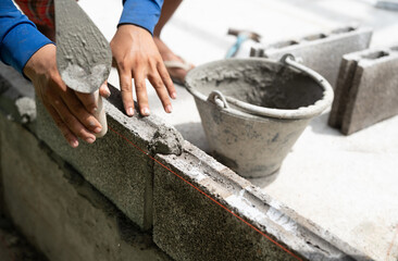 Hand worker masonry brickwork trowel construction site wall concrete background