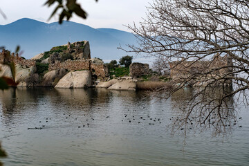 small island with historical ruins at Bafa Lake, dry tree, volcanic rock formation on waterfront