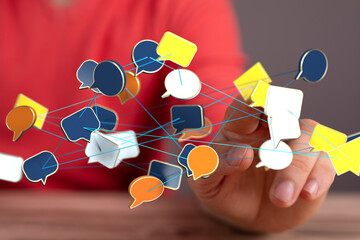 Hand interacting with a network of speech bubbles, symbolizing global communication and...