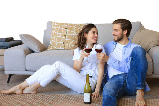 Happy couple sitting, relaxing on floor, drinking red wine. Smiling young husband and wife rest enjoy romantic date on family weekend together on a transparent background