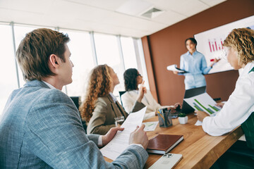 Professional team collaborating on business strategies in a modern office space during a work...