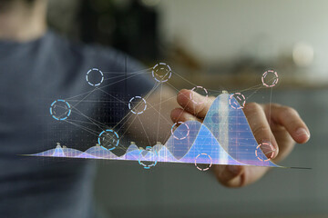 Person interacting with a holographic graph, visualizing data points and trends for business...