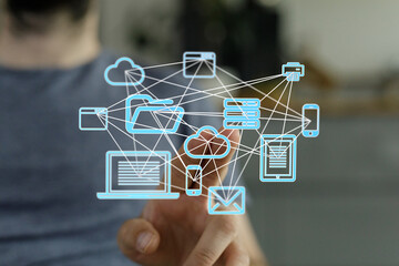 A man interacts with a digital network visualization showcasing cloud computing, data storage, and...