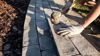 Laying paving stones on cement mortar. Laying a garden path made of tiles. Self-laying of concrete...