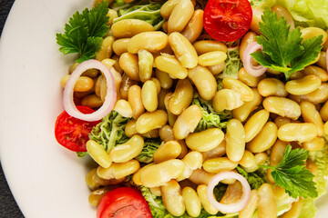 Bean salad green leaf lettuce, tomato, onion vegetables dish fresh delicious gourmet food background on the table rustic food top view copy space keto and paleo diet vegan and vegetarian food