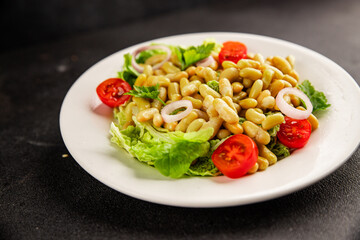 Bean salad green leaf lettuce, tomato, onion vegetables dish fresh delicious gourmet food background on the table rustic food top view copy space keto and paleo diet vegan and vegetarian food