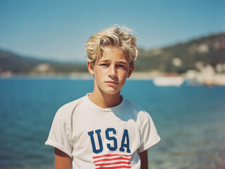 Vintage Portrait of a blonde Teen Boy Wearing USA Shirt by Lake – 4th of July Summer Film Photo