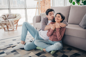 Fototapeta premium Young couple enjoying happy moments together indoors in a cozy living room filled with bright daylight, showcasing love and bonding