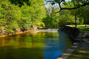 A small spillway on the Rocky River in Rocky River Reservation near Cleveland, Ohio, catches brilliant early-evening spring sunlight