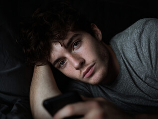 Man sitting on phone late at night, insomnia.