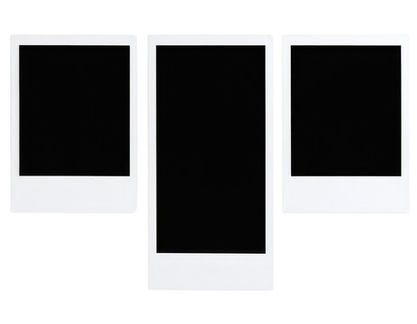 Three blank instant photo frames with white borders arranged side by side on a black surface.