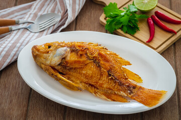 Deep fried red tilapia fish on white plate