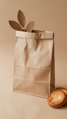 Minimalist composition of a plain brown paper bag with decorative paper leaves and baked goods on warm beige background


