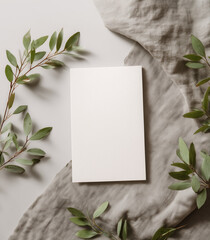 white card mockup with blank space for text, flat lay, soft gray background, with some green leaves and cloth in the background, minimalist style