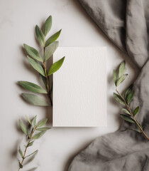 white card mockup with blank space for text, flat lay, soft gray background, with some green leaves and cloth in the background, minimalist style