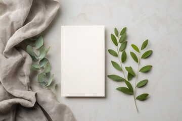  white card mockup with blank space for text, flat lay, soft gray background, with some green leaves and cloth in the background, minimalist style
