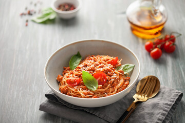 Pasta Spaghetti Bolognese in white plate on gray background. Bolognese sauce is classic italian...