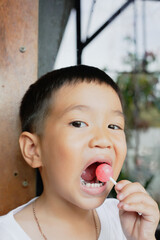 This boy lost his teeth from eating sweets and nibbles, which is likely due to natural loss. His smile reveals gaps where teeth used to be, giving him an attractive, young, and cheerful appearance.
