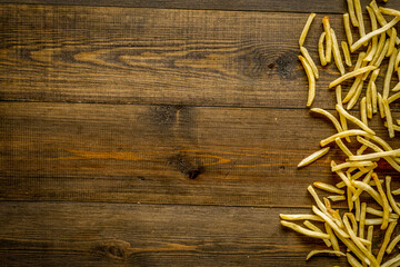 French fries frame on dark wooden background top-down copy space