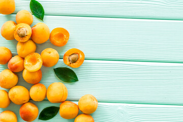Fruit frame. Apricots and leaves on green wooden background top view space for text