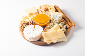 Wooden charcuterie board with various cheese and olives. Brie. Camembert. Parmesan, feta, blue cheese. Italian, French cheese