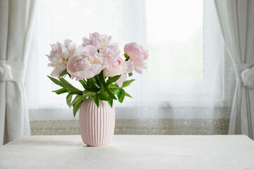 Elegant pink peonies beside the window. Slow living. Light home decoration with flowers and pink...