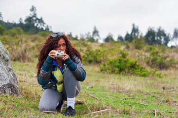 Young woman taking pictures in nature with analog camera.Photography day