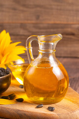 Sunflower oil and sunflower seeds on traditional rustic wooden background. Organic and eco food concept. Healthy food and fats.