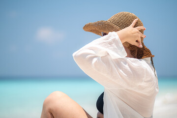 woman relax on summer resort, woman smiling while lying on sandy beach wearing a straw hat and white shirt, bright sunny tropical atmosphere in maldives, island vacation, summer happiness