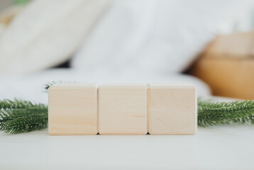 Wooden blocks arranged on a soft surface with greenery in a cozy setting