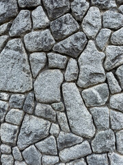 Vertical rough stone wall texture with natural granite masonry pattern