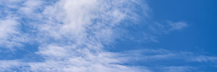 Clear blue sky with a few clouds. The sky is very bright and the clouds are scattered throughout