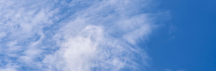 Clear blue sky with a few clouds. The sky is very bright and the clouds are scattered throughout