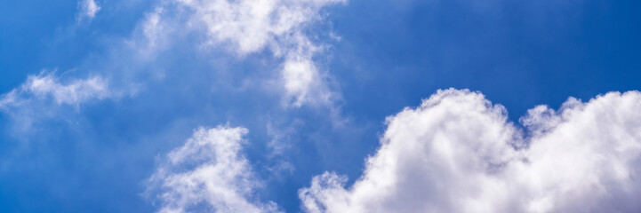 Clear blue sky with a few clouds. The sky is very bright and the clouds are scattered throughout