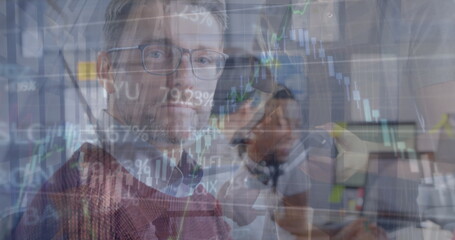 Focusing analyst in burgundy sweater reading stock charts in office, with coworker using smartphone