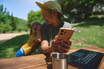 Woman Working Remotely at Outdoor Destination with Child and Digital Devices