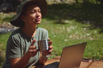 Woman Enjoying Outdoor Work with Laptop and Mug in Nature